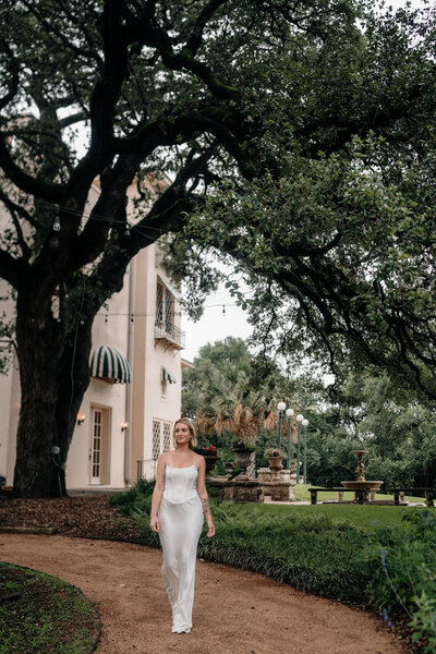 Bride walking at Laguna Gloria in a Italian Villa Styled Building