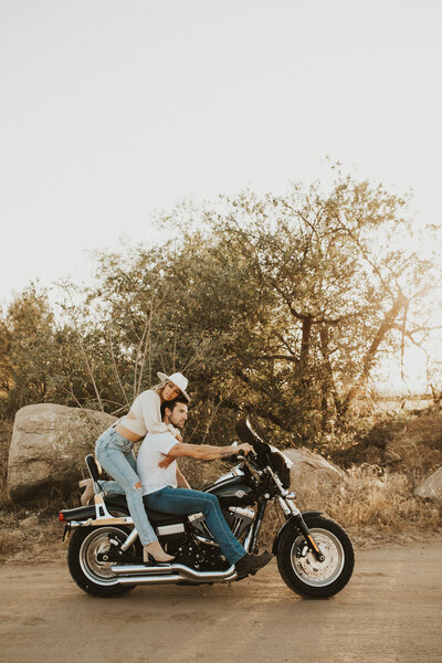 couples poses on the back of a harley for their couples photoshoot