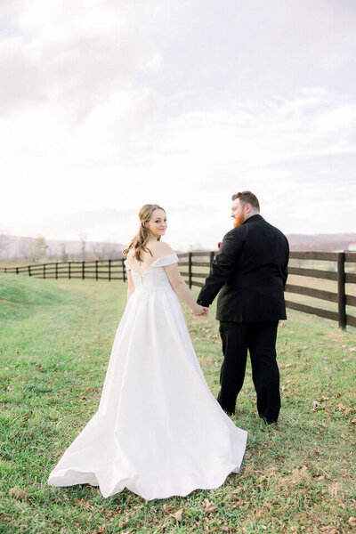 In the fields of the Marriot Ranch Hotel we have a Bride wearing a beautiful white dress looking at the camera while her husband admires her in love.