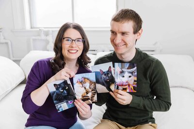Alicia and husband holding photos of their 5 cats