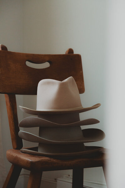 Vintage western hats stacked on a wooden chair