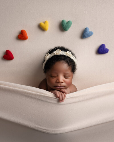 Newborn baby photography with rainbow hearts backdrop Austin professional photographer