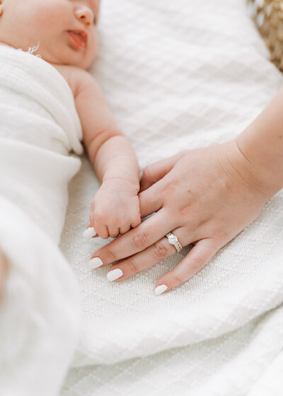 Woman holding baby and smiling at the camera