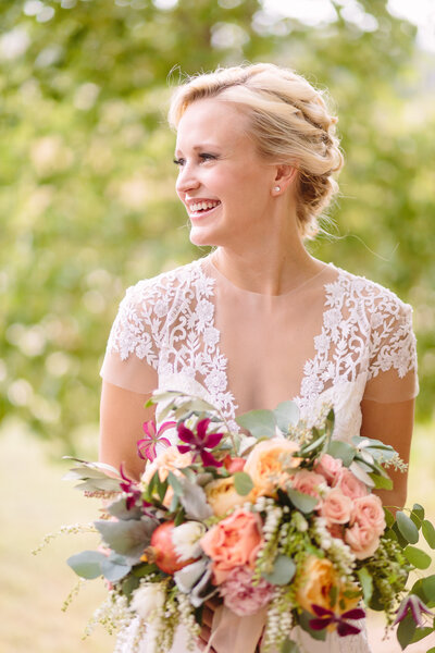 happy bride in lace dress updo and makeup
