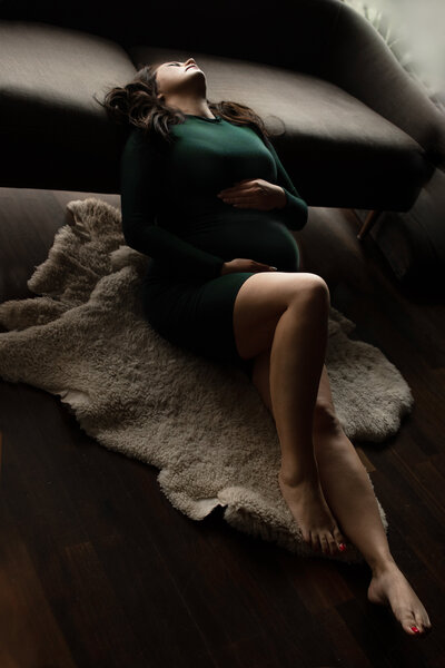 maternity photo of woman laying down in robe