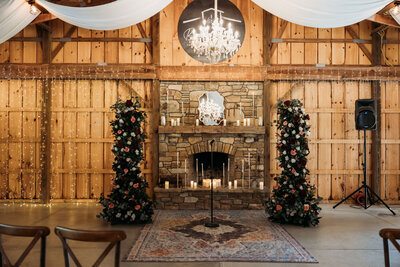 Cozy fireplace decorated with flowers in a wooden barn setting