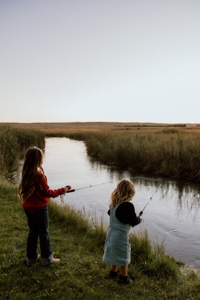 family photos taken on a nebraska ranch with girls fishing and enjoying the sunset. 