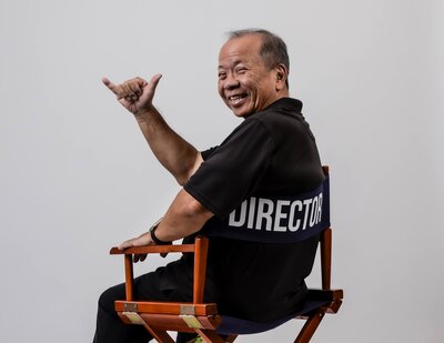 Portrait of Carlton Saito giving a shaka.