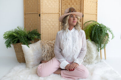 motional recovery coach dressed in a beautiful pink and white outfit, meditating to feel free and happy. This image symbolizes the journey of emotional healing and finding peace after experiencing infidelity.