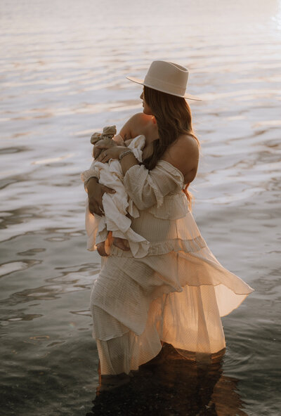 Mother holding her baby in a lake