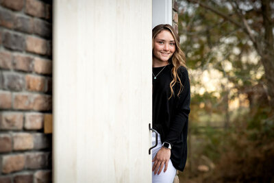 girl peeking out a sliding door  in the  prop shed