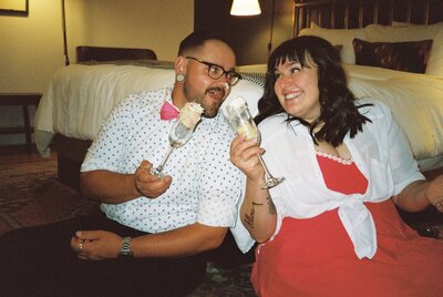 Engagement session at the Armstrong Hotel with couple sharing cake in champagne flutes captured on 35mm film