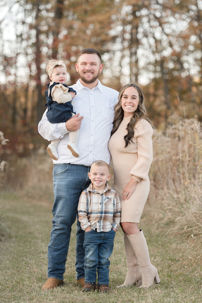 family of 4  posing along ludington yacht club during their michigan family session
