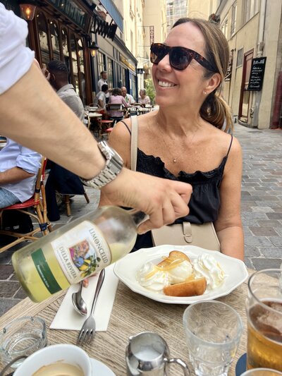 Woman sitting at a cafe being served dessert