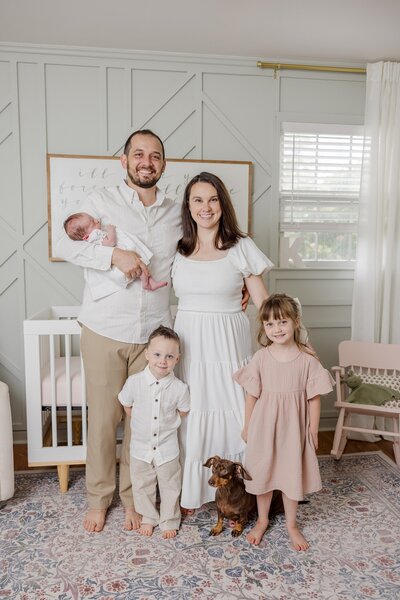 Parents holding newborn while standing in his blue and white nursery. - Newborn Photography Greenville SC