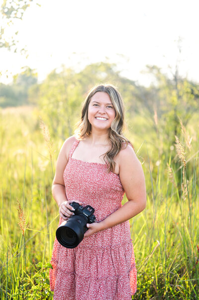 woman holding camera and smiling