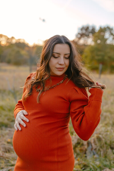 Pregnant woman holding belly during Fall maternity session in Wheaton, IL