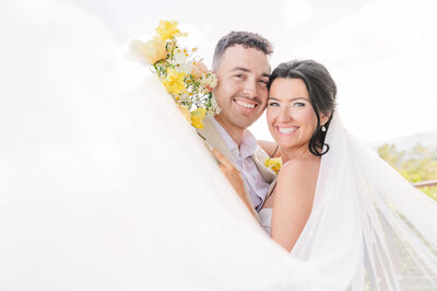 A smiling couple dancing on a wrap around deck in the Smoky Mountains during their summer wedding by JoLynn Photography, a North Carolina wedding photographer