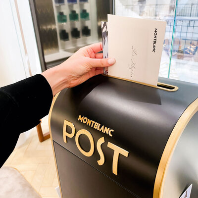 Handwritten envelope being placed into a Montblanc postbox