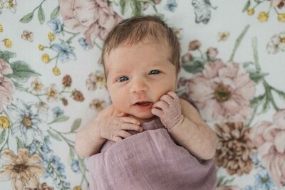Newborn baby on floral sheet