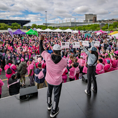 Charizma DJ energizing the crowd at a Chicago charity walk with hundreds of attendees in pink
