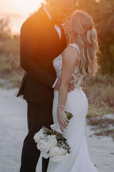 bride and groom embracing at sunset