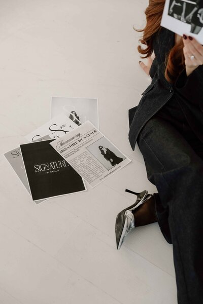 Natalie sitting on the ground with branding materials next to her