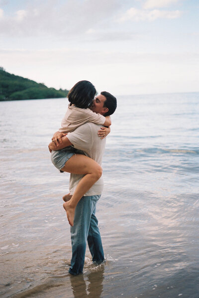 Couple embraces while standing in the ocean