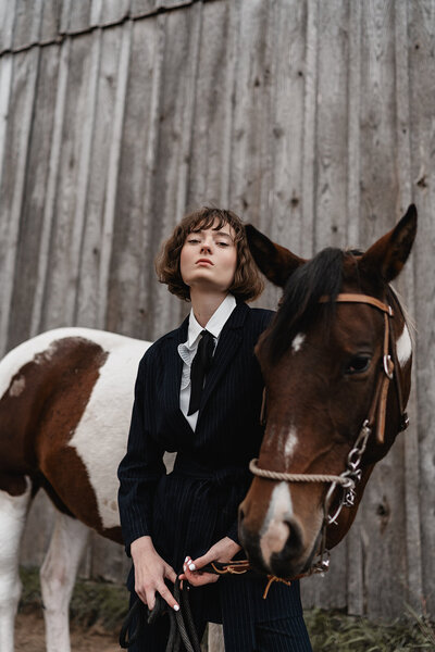 Editorial model in a black suite with gold statement earings