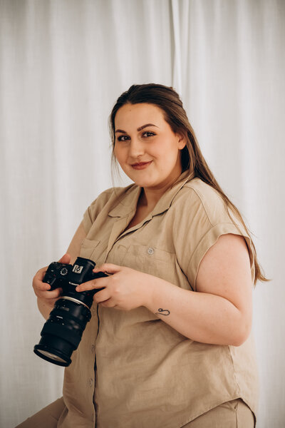 A person smiling and holding a camera