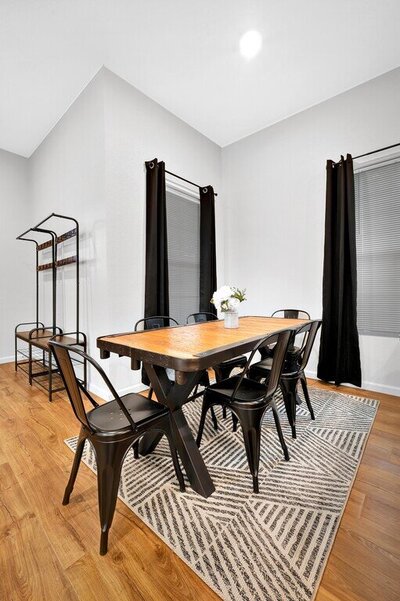 Dining room table that seats six in this three-bedroom, two-bathroom home with fully stocked kitchen, large backyard, grill, and basketball hoop in downtown Waco, TX.