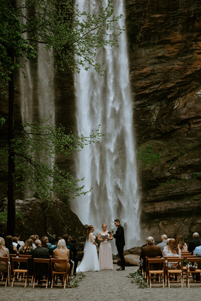A couple reads their vows during their intimate wedding in front of a big waterfall in North Georgia.