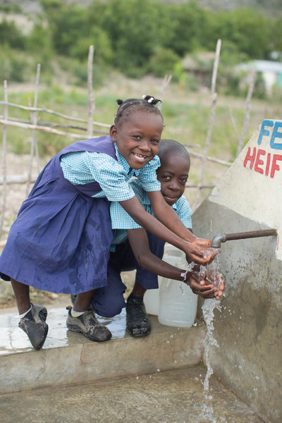 Two children holding goats during humanitarian photoshoot