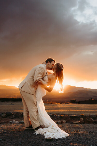 A couple kiss on a patch of snow in the Ouray mountains.