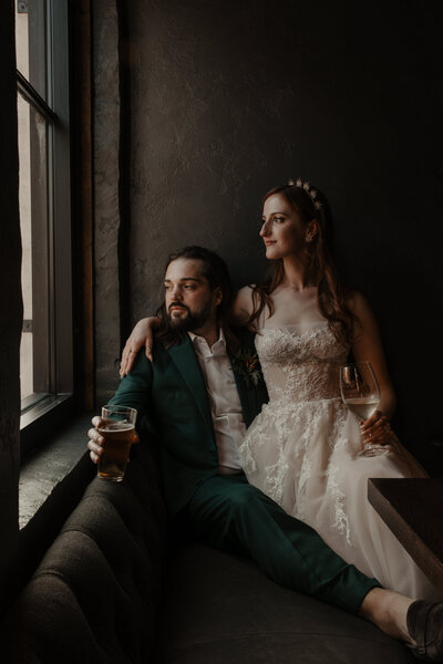 bride and groom embracing at reception with moody window light