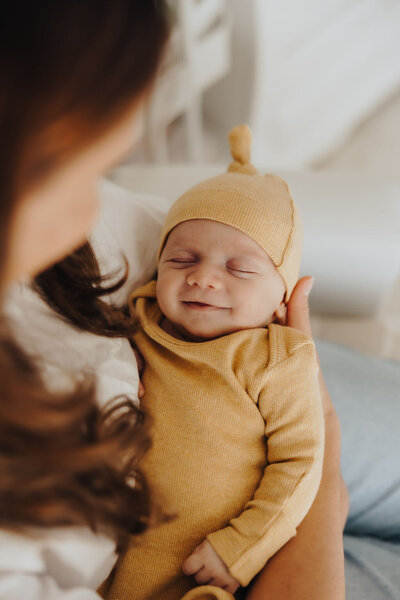 Newborn baby in yellow jumper