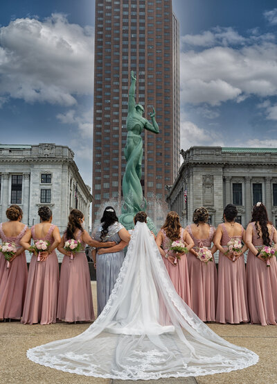 Experience the beauty and elegance of a Cleveland wedding with our professional photography. This stunning photograph captures the joy and happiness of the bride and bridesmaids in front of the iconic Fountain of Eternal Life. Contact us for timeless and captivating wedding photography