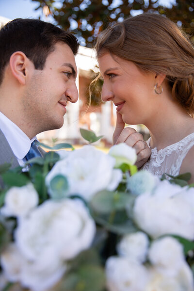 Wedding couple surrounded by bouquet of flowers.