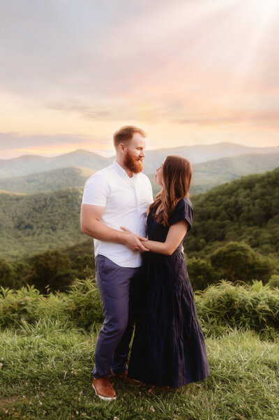 Couple embraces for Family Photos on the Blue Ridge Parkway in Asheville, NC.