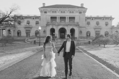 a bride and groom walk down the private drive of elstowe manor at elkins estate. image by philadelphia wedding photographer emily wilkerson