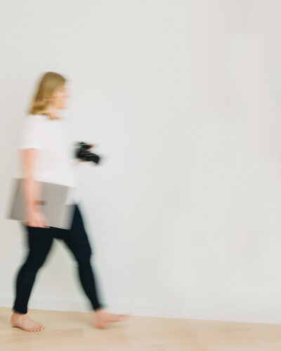 Natasha Sewell walking with computer and camera