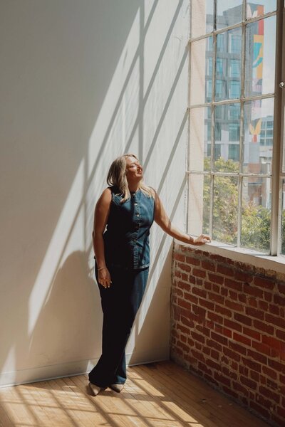 An image capturing natural light and shadow, offering website design inspiration. A woman looking towards the window can represent vision and creative ideas for impactful website design. Use this aesthetic for inspiring visuals on your website