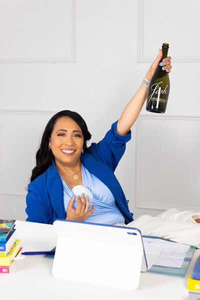 Bilingual leadership coach from HR Mami Career Coaching in her personal office with tools and champagne, celebrating Latina professionals and their career success