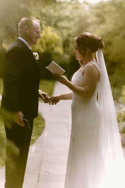 Bride and groom reading private vows during ceremony