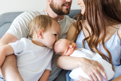 little boy kissing his new brother for lifestyle newborn session