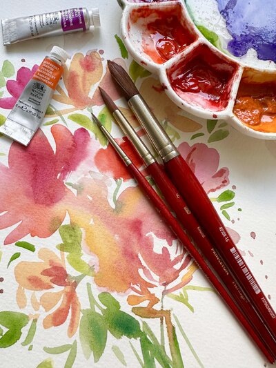 Colorful watercolor flower painting and paint brushes  with paint