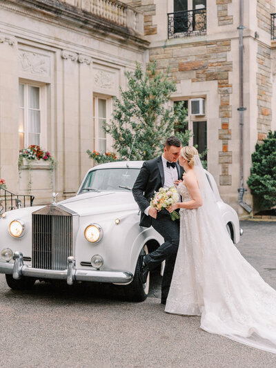 Bride and groom nose to nose in front of vintage car photographed by Cincinnati Catholic wedding photographers Laura and Matthew