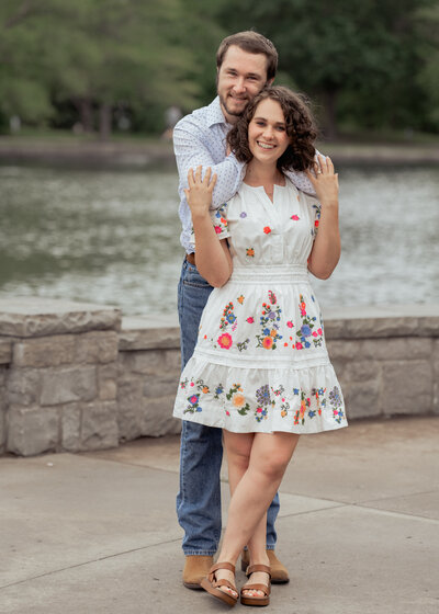 A couple hugs and smiles at the camera during their engagement session at Centennial Park in Nashville, Tennessee.