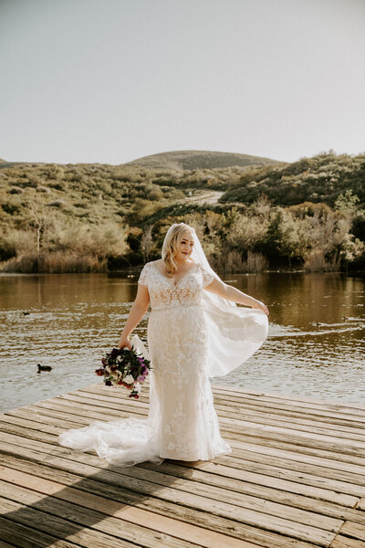 bride posing on dock by lake