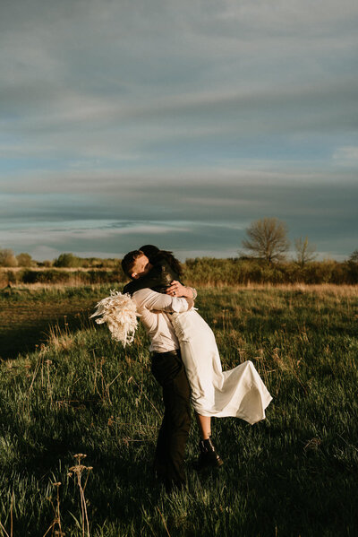 Elopement couple embracing at sunset.